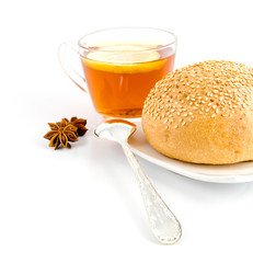 roll with sesame,tea spoon and anise on the background of tea wi