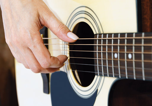 hand on an acoustic guitar