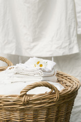 Basket full of clean freshly washed grandmother's linens. Outdoor, laundry hanging background.
