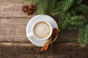 Obraz na płótnie Canvas A cup of coffee with the branches of the Christmas tree on a wood