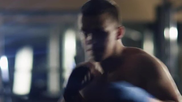Professional male boxer is training punches and kicks in the gym. Shot on RED Cinema Camera.
