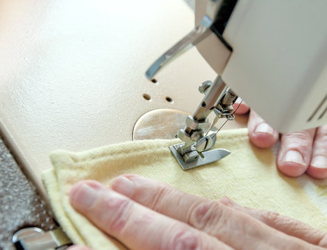 hand of the old woman at the sewing machine