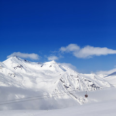 Winter snowy mountains and ski slope at nice day.