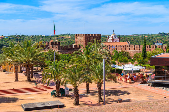 Palm trees on square of medieval castle in Silves town, Algarve region, Portugal
