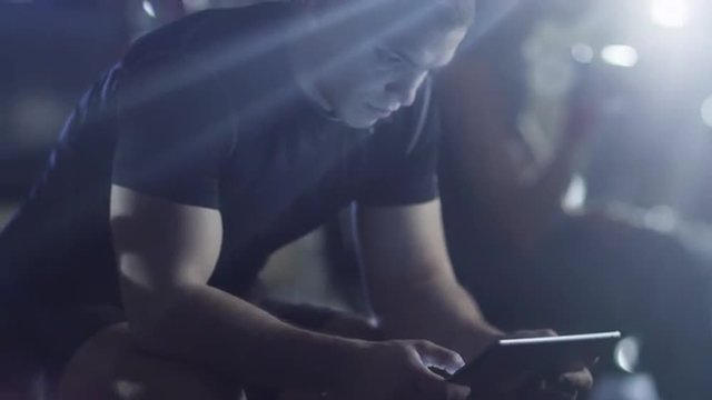 Handsome fit sporty man is using a tablet computer in the gym. Shot on RED Cinema Camera.