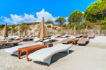 Sunbeds on Palombaggia beach on sunny summer day, Corsica island, France