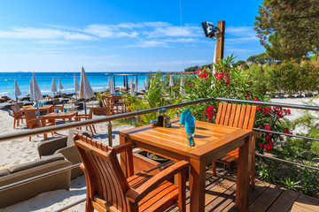 Fototapeta na wymiar Restaurant table with chairs on Palombaggia beach, Corsica island, France
