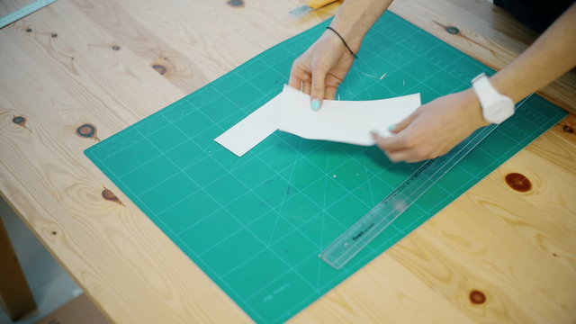 woman cuts the paper on the table