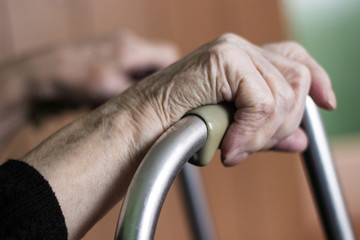 Elderly hands on a walker 