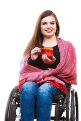 Woman invalid girl on wheelchair holds tea mug