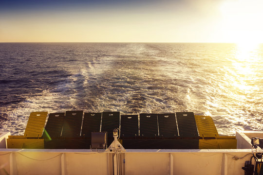 Wake of a ferry boat crossing the sea with track lines in the su