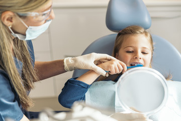 Doctor dentist teaching a child to brush teeth