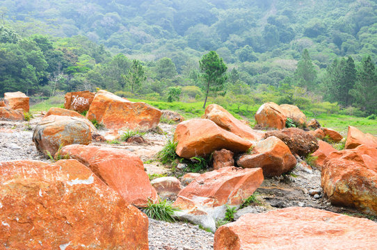 The bottom of the crater of the Tecapa volcano with rocks naturally painted in orange by the waters of the sulphur lake, near the town of Alegria in El Salvador