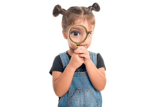 Baby girl  looking  through a magnifying glass
