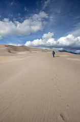 A lone woman hikes up the dunes near Sand Dunes National Park in southern Colorado.