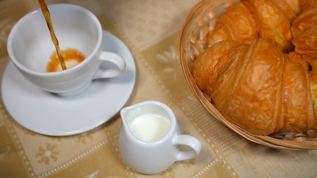 Pouring Coffee into Cup with Croissant