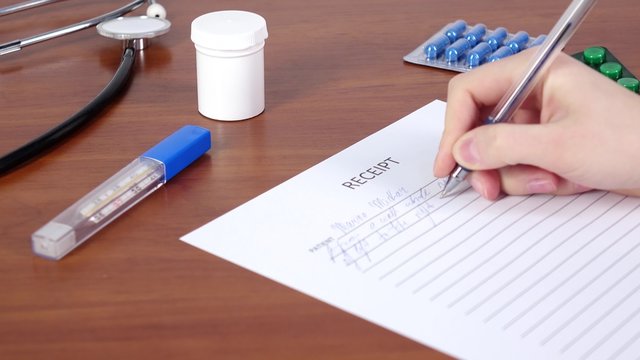 Doctor continue writing a receipt for patience