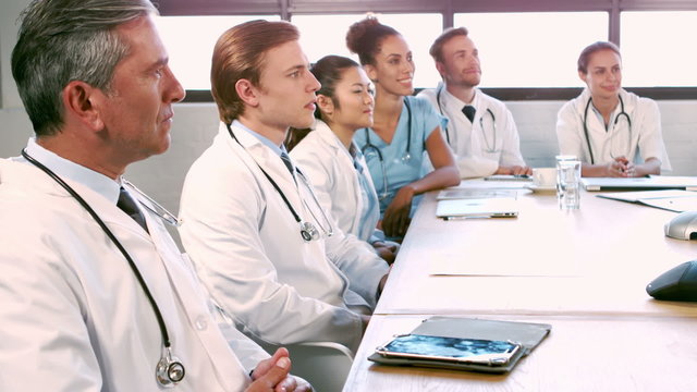 Medical team talking together while applauding