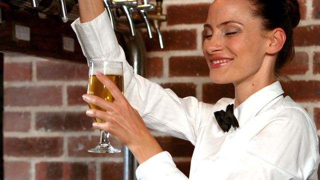 Barmaid pulling a glass of beer 