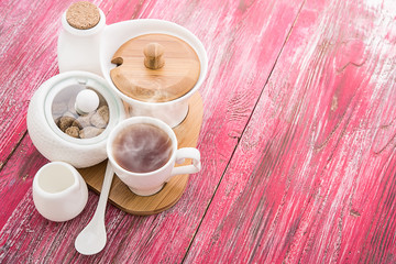Tea cups with teapot on old wooden table