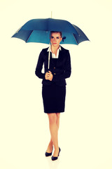 Blonde businesswoman holding an umbrella