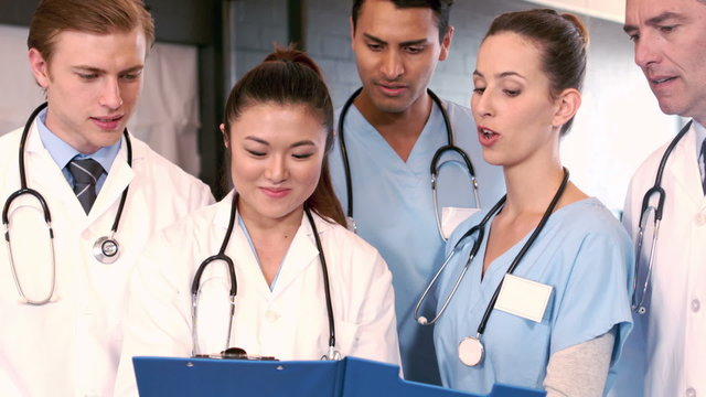 Medical team talking together while looking clipboard