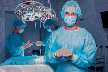 Team surgeon at work in operating room. breast augmentation.