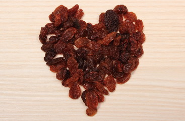 Heart of raisins on wooden table, healthy eating and symbol of love
