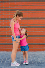 Happy mother and her daughter playing outdoors in summer.