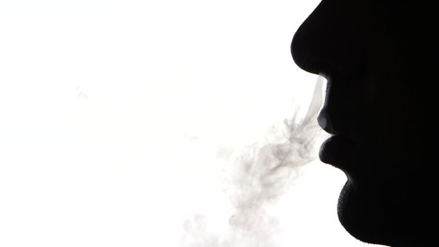 Man smoking electronic cigarette, cam moves to the left, on white, silhouette