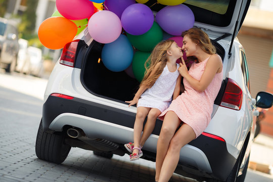 Mom And Daughter In A Car With Balloons