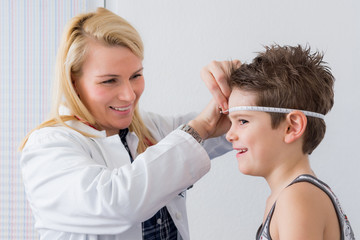 ärztin kontrolliert den kopfumfang vom kind