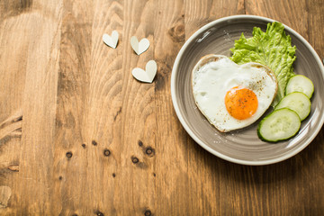 Romantic breakfast with scrambled eggs in a heart-shaped Valentine's Day