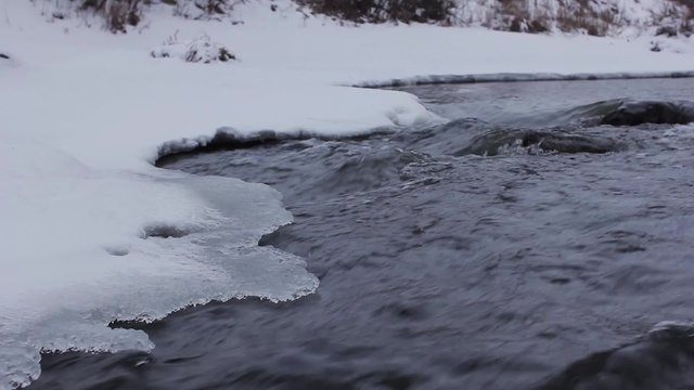 Frozen river in winter, water and snow