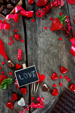 hearts, chocolate, flowers and ribbons on wooden surface