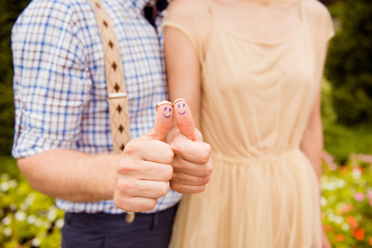 Closeup photo of a happy couple in love holding wedding rings on