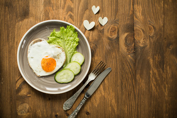Romantic breakfast with scrambled eggs in a heart-shaped Valentine's Day