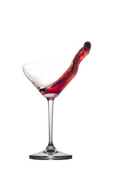 Red cocktail splashing from glass isolated on white background