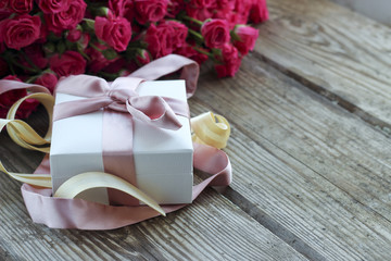 Holiday background with pink roses and gift box