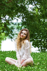 Young blonde woman on green meadow