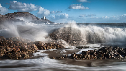 Crashing waves and Mumbles lighthouse on the Gower peninsula, South Wales.