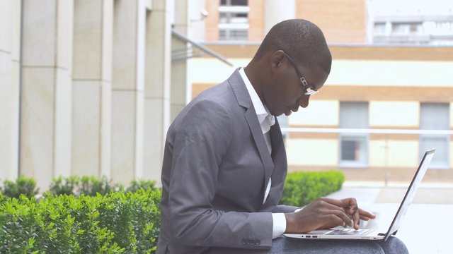 African American entrepreneur displaying computer laptop on. outdoors