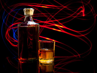 bottle and glass of whiskey with ice on dark background,curved g