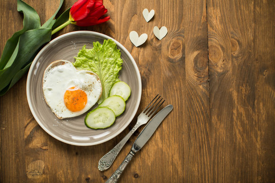 on Valentine's Day, fried eggs in the shape of a heart and fresh vegetables