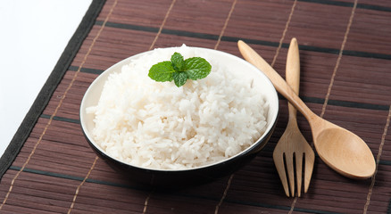 bowl full of rice and spoon on wood background