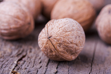 Pile of walnuts the shell on a wooden background