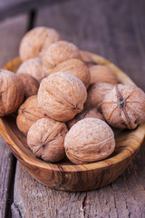 Pile of walnuts the shell on a wooden background