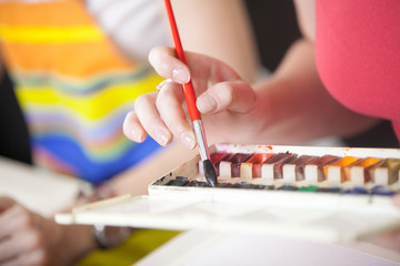 The girl draws paints