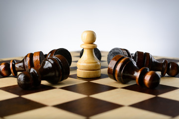 White pawn surrounded by black pawns