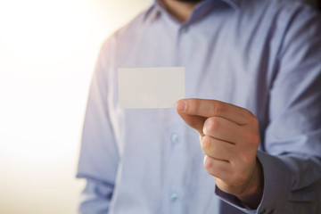 Man holding white business card 